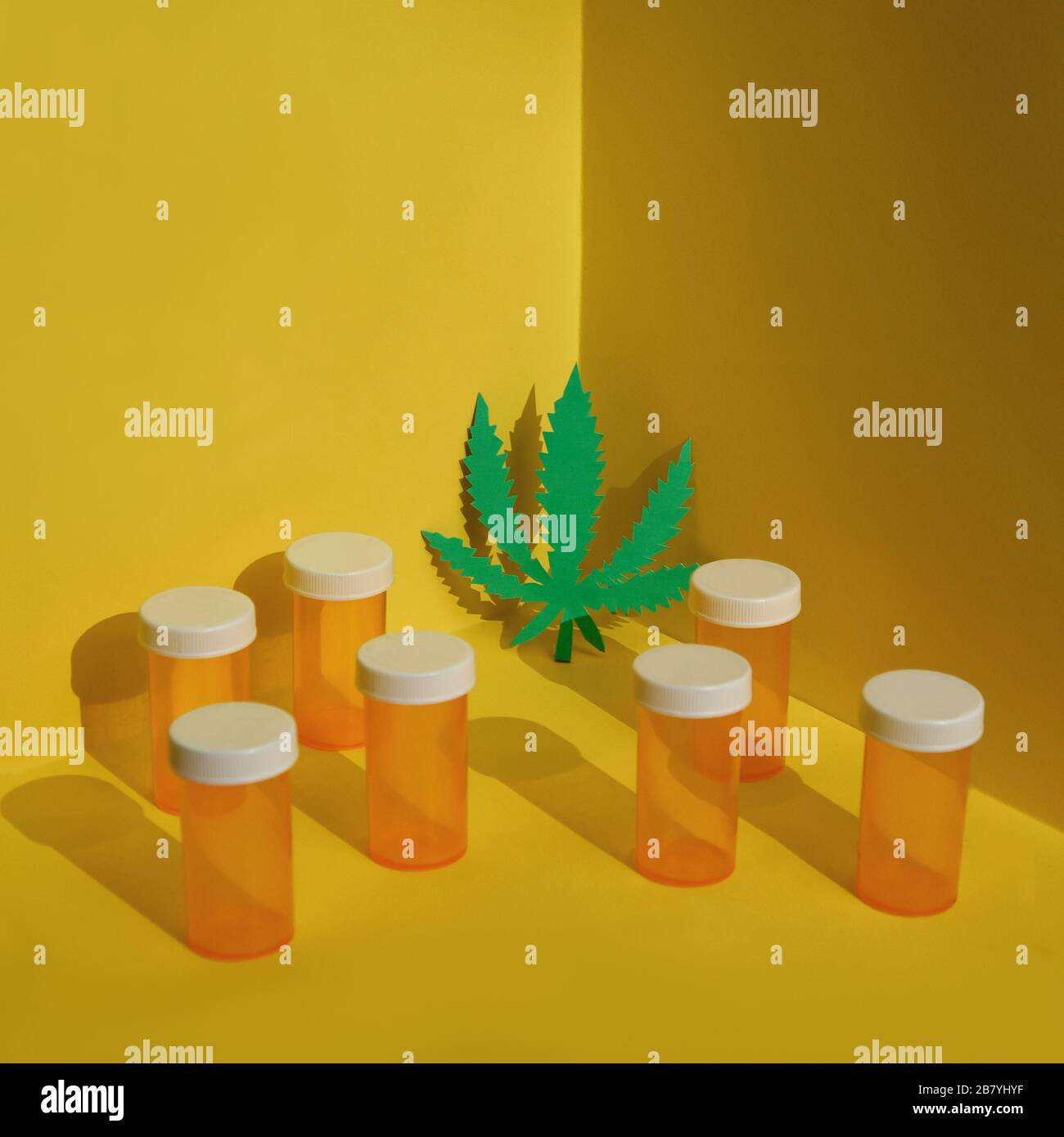 Una foglia di marijuana è in un angolo con bottiglie di prescrizione intorno ad esso per un concetto di medicina alternativa. Foto Stock