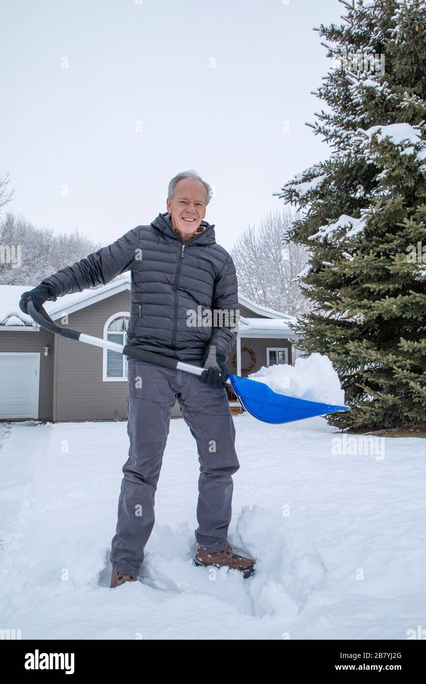 Uomo anziano che tovana la neve Foto Stock