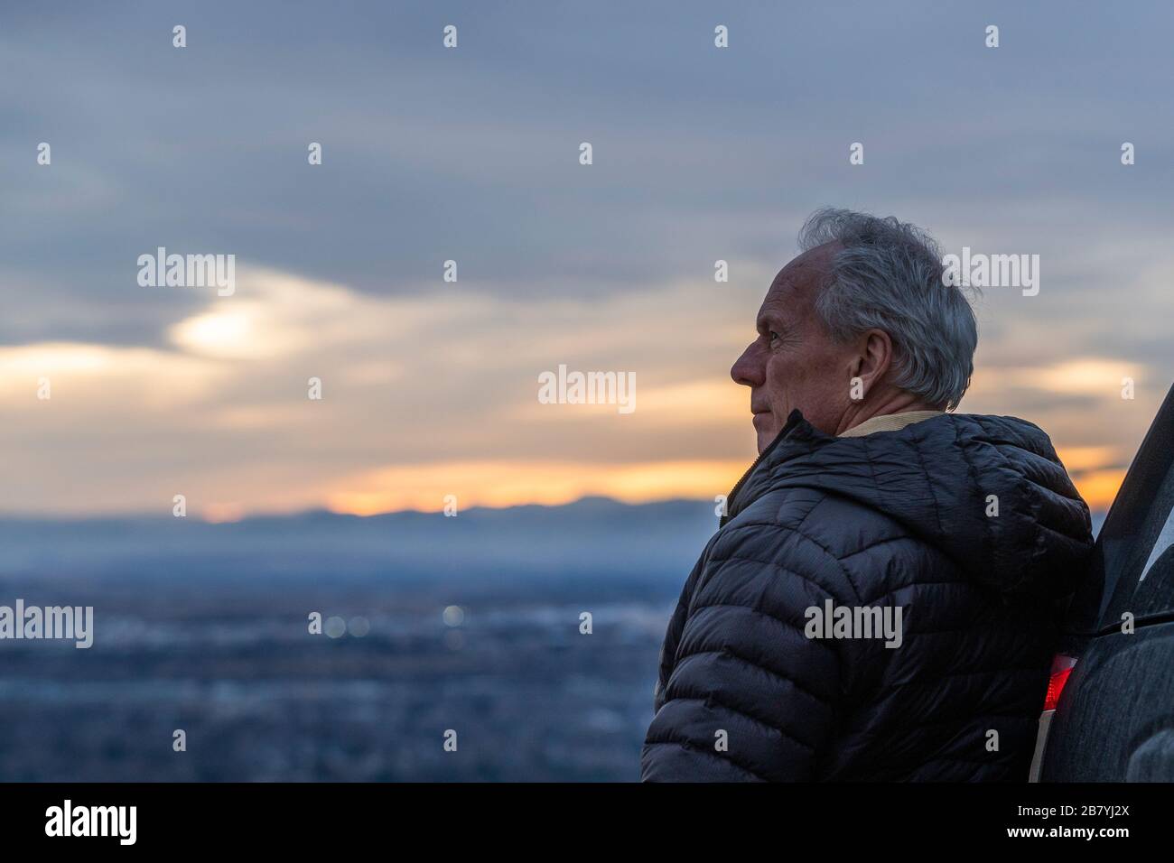 Uomo anziano che guarda la vista durante il tramonto Foto Stock
