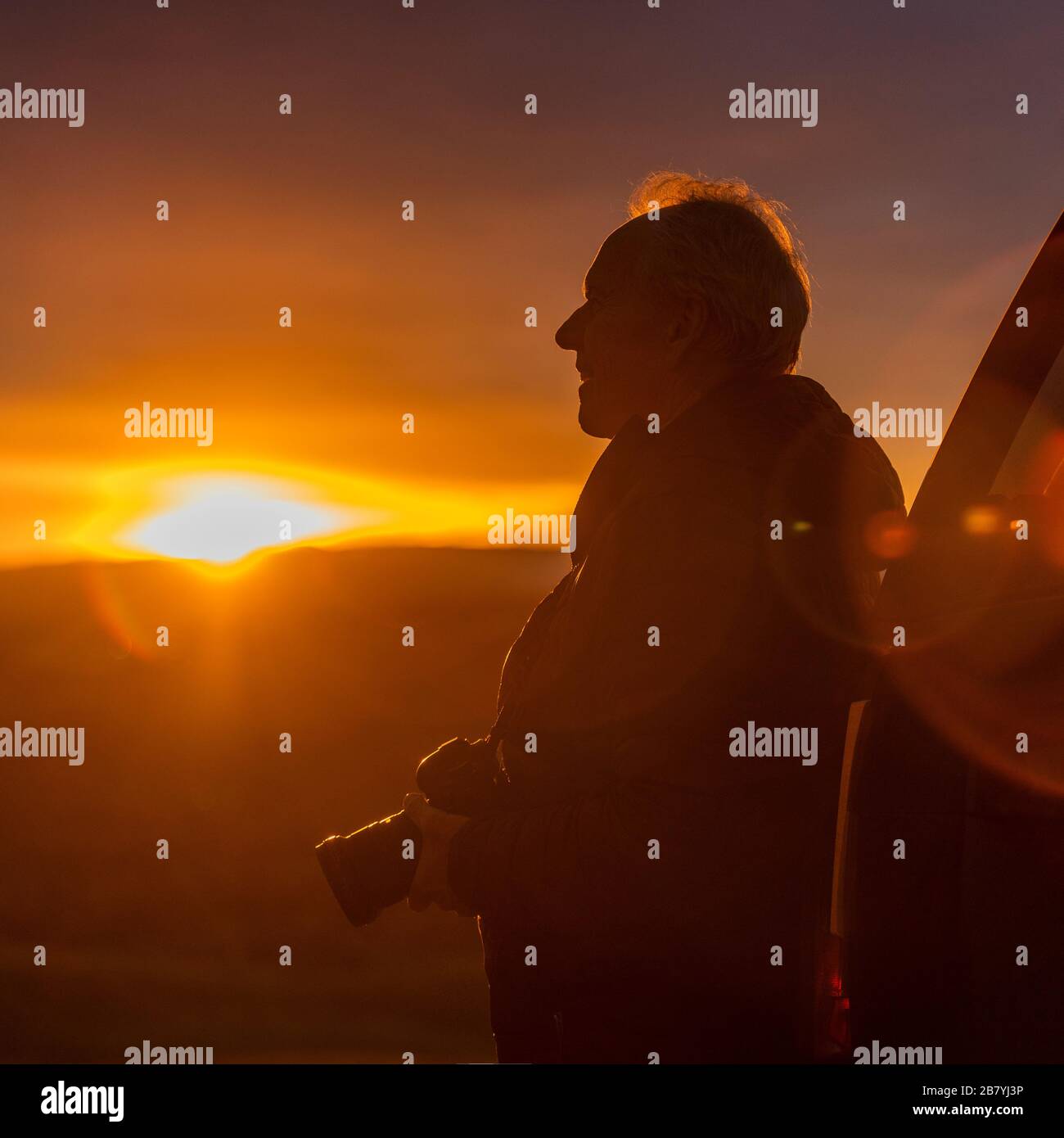 Uomo anziano con macchina fotografica al tramonto Foto Stock