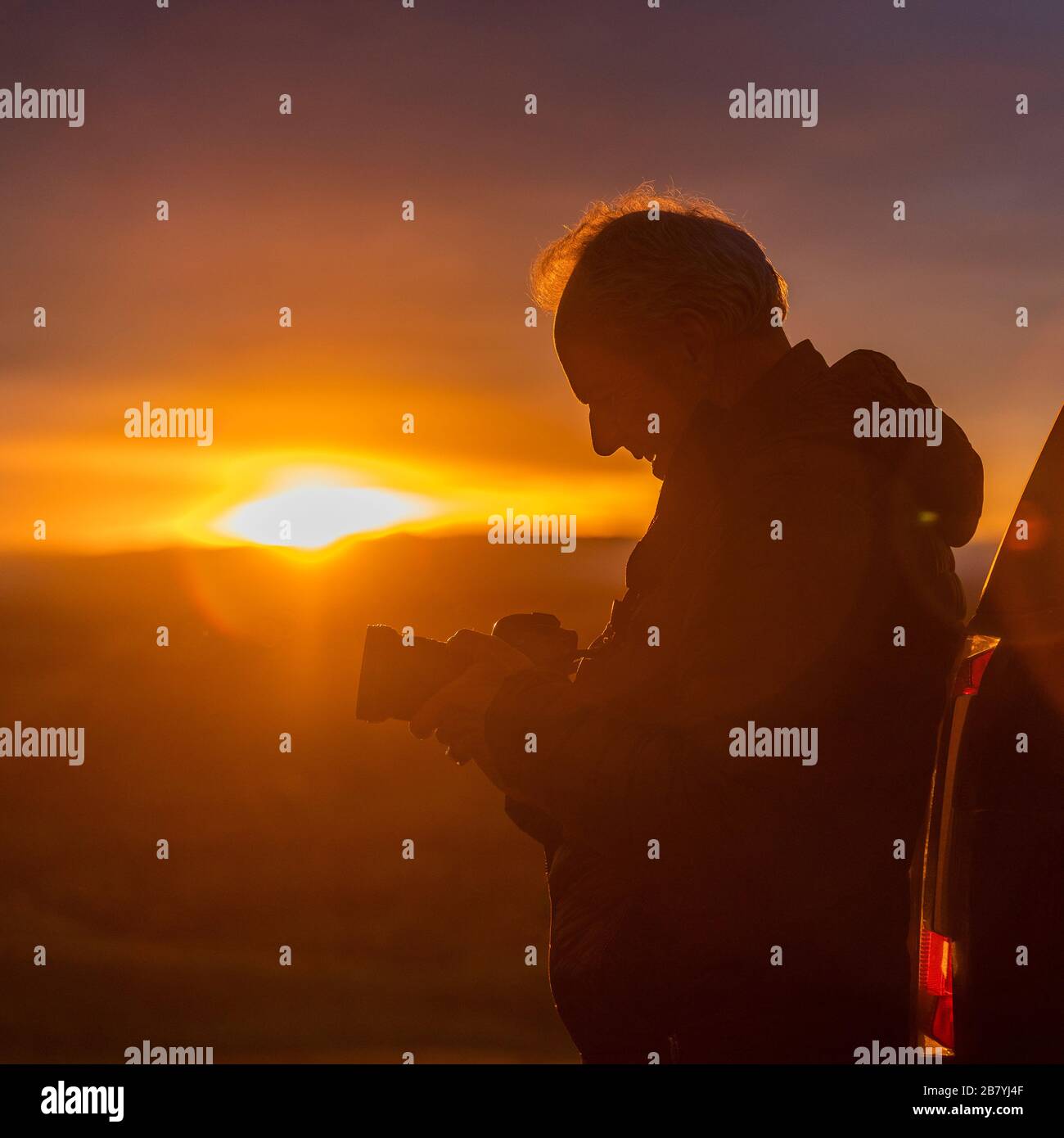Uomo anziano con macchina fotografica al tramonto Foto Stock