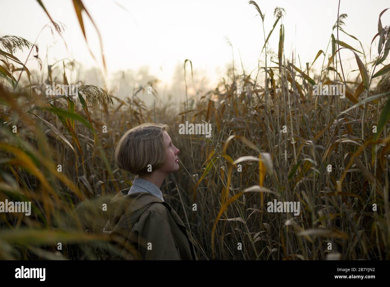 Giovane donna in campo di erba lunga Foto Stock