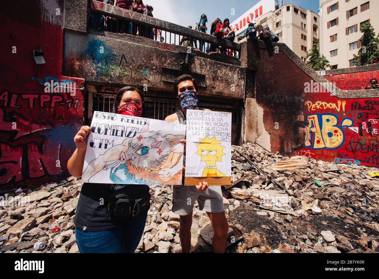 SANTIAGO, CILE-29 OTTOBRE 2019 - un paio di studenti mostrano i loro proclami nelle rovine della stazione della metropolitana di Baquedano, vandalizzata durante severa Foto Stock