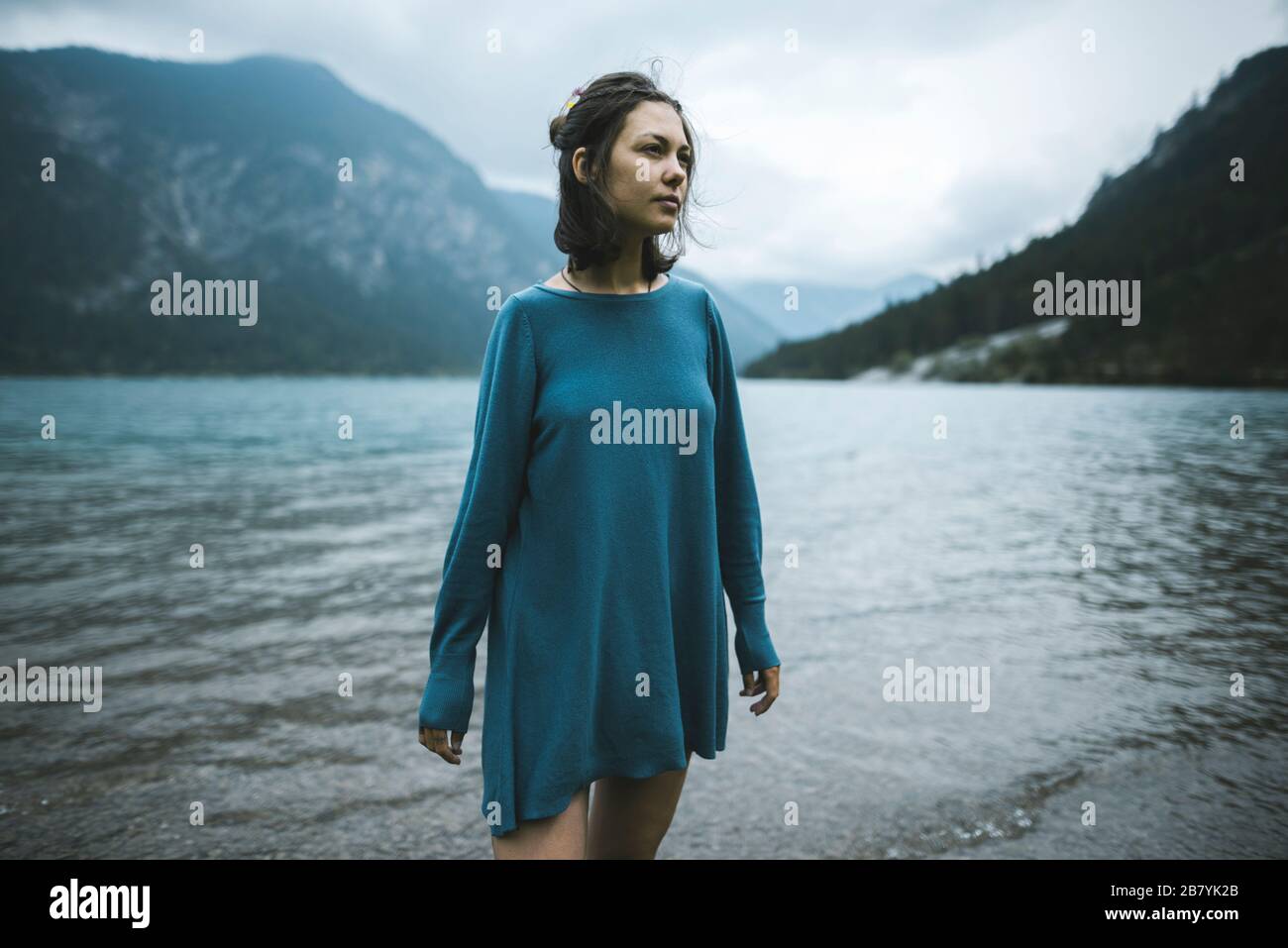 Giovane donna in pullover blu sul lago Foto Stock