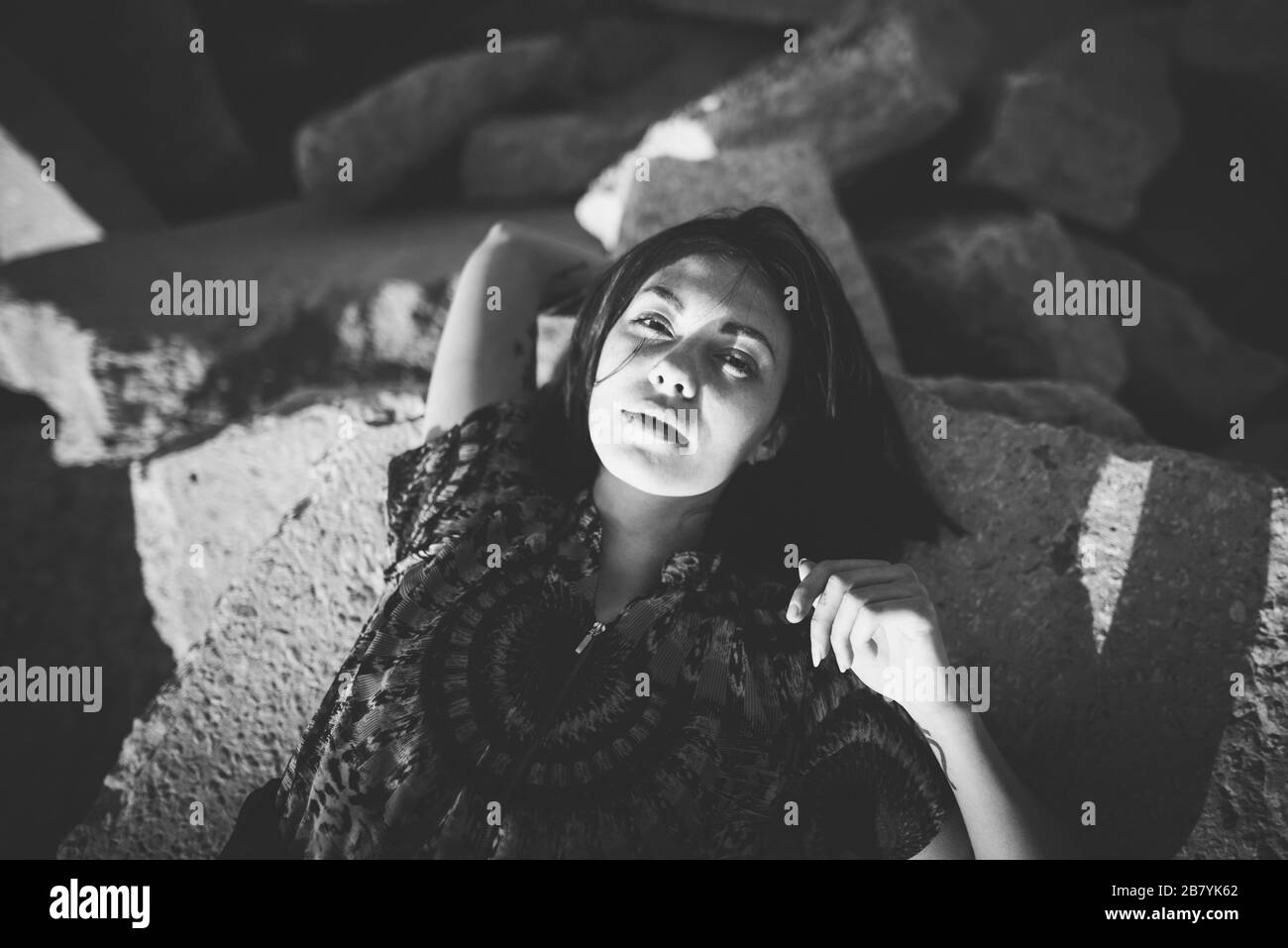 Giovane donna sdraiata su rocce Foto Stock