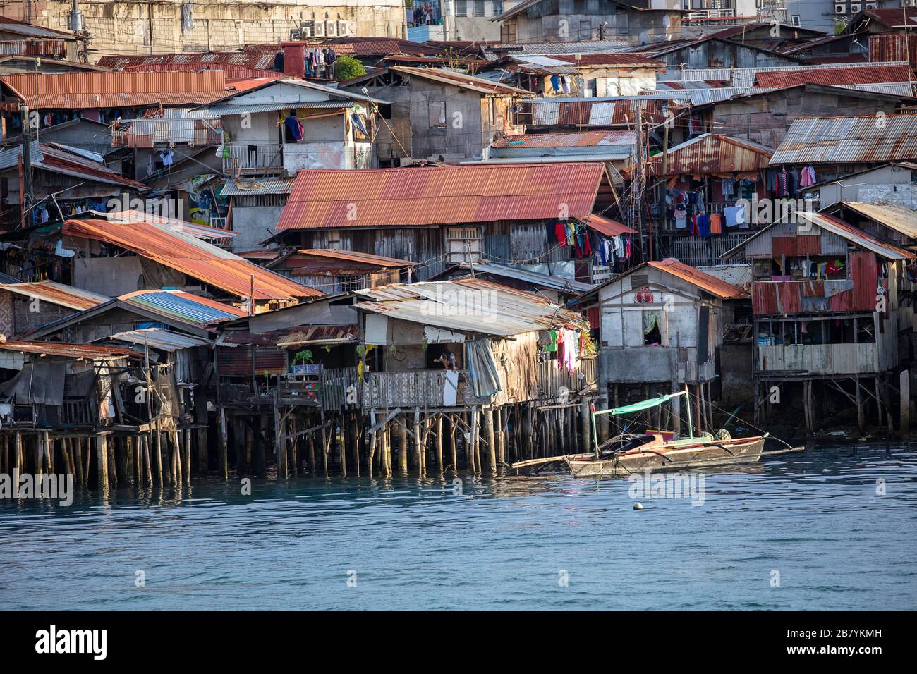 Quartieri poveri baraccopoli con case di legno su acqua, Cebu città, Filippine. Foto Stock