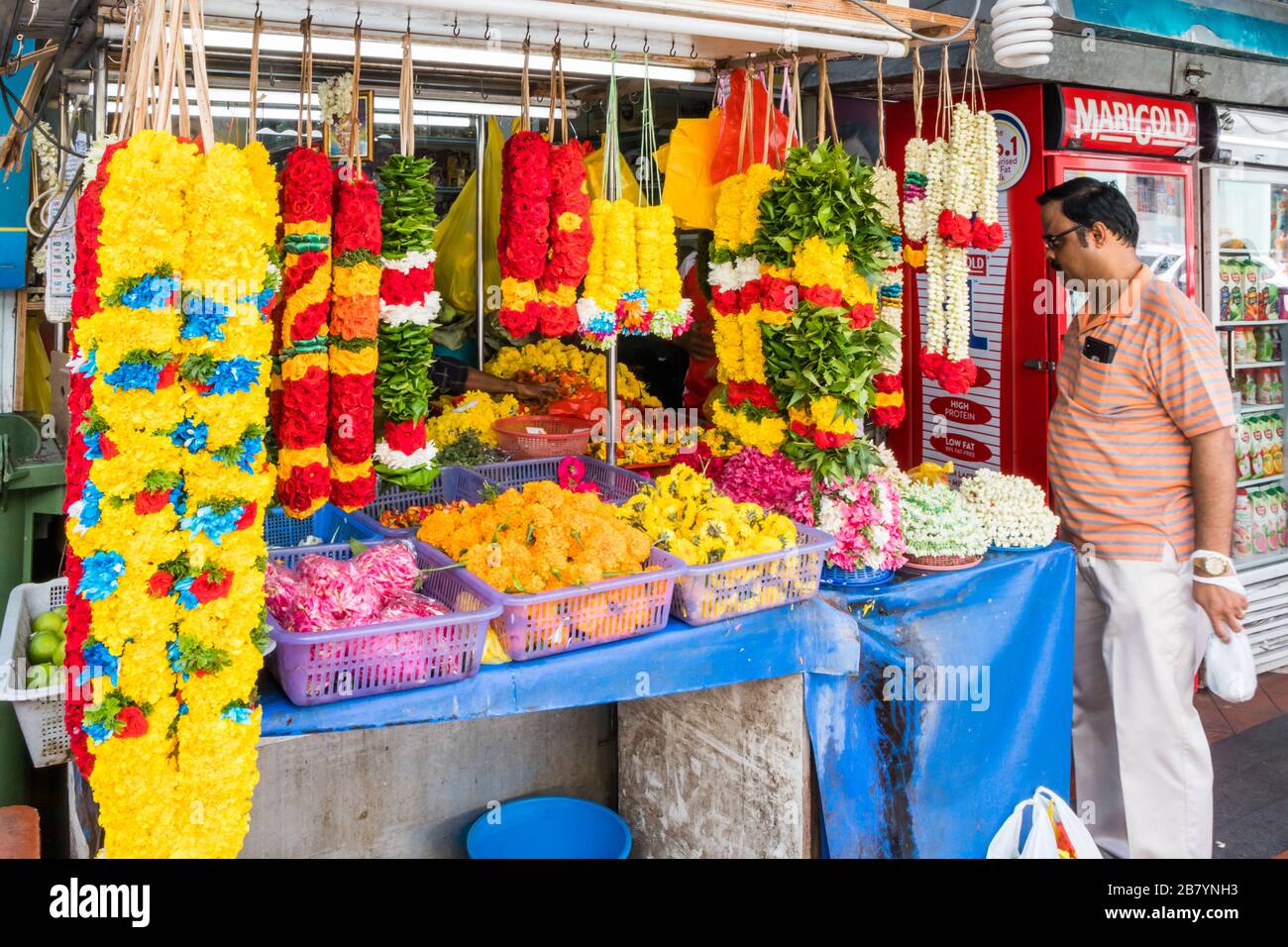 Singapore - 6 Luglio 2019: Uomo che acquista garlands in Little India. Molti degli edifici sono patrimonio storico. Foto Stock