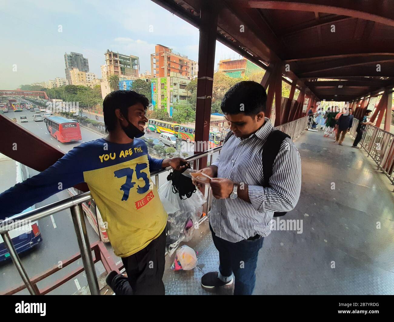 Un cliente che contrattava con un falco di maschera per bye maschera da lui a Banani, Dhaka. A causa del virus Corona, la domanda di maschera è attualmente alla massima richiesta. Foto Stock