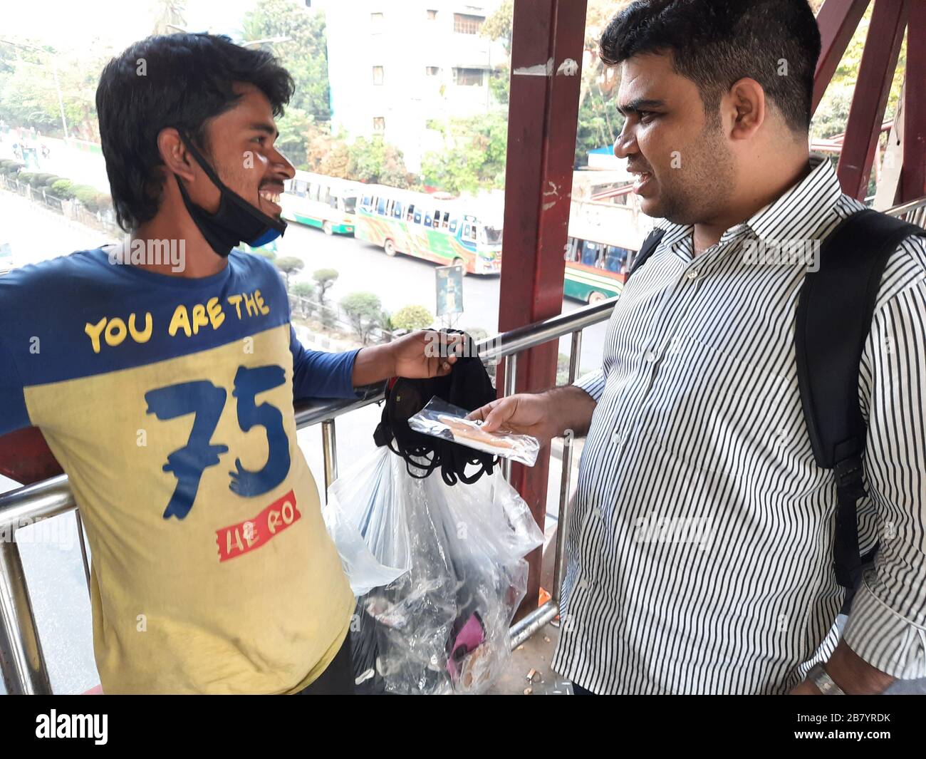 Un cliente che contrattava con un falco di maschera per bye maschera da lui a Banani, Dhaka. A causa del virus Corona, la domanda di maschera è attualmente alla massima richiesta. Foto Stock