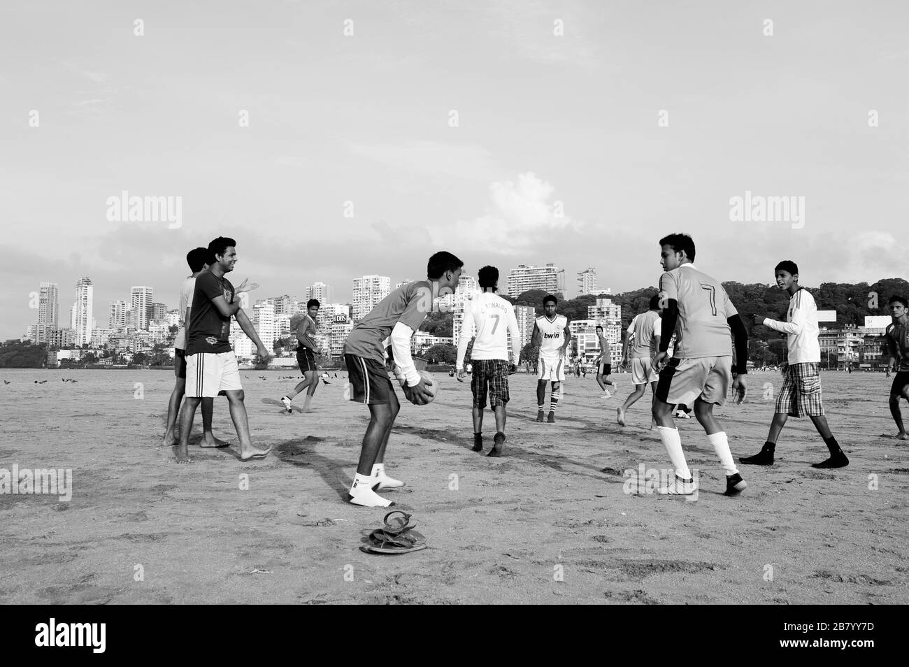 Ragazzi che giocano a calcio sulla spiaggia, Chowpatty, Girgaon, Bombay, Mumbai, Maharashtra, India, Asia Foto Stock