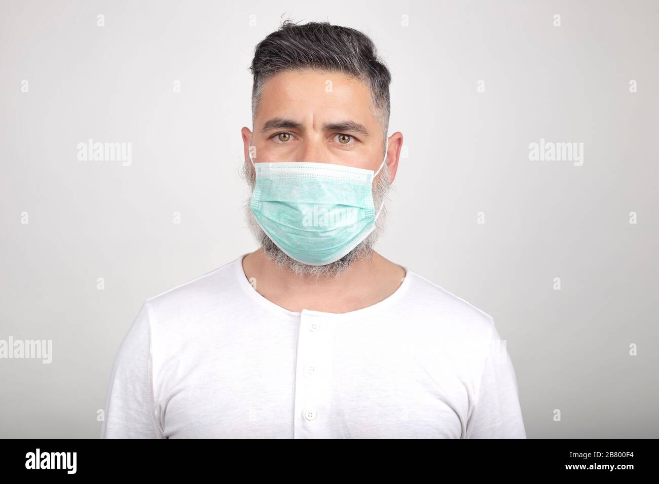 Coronavirus, un uomo con maschera medica su sfondo bianco. Titolo sullo scoppio del virus della corona, malattia. Epidemia Foto Stock