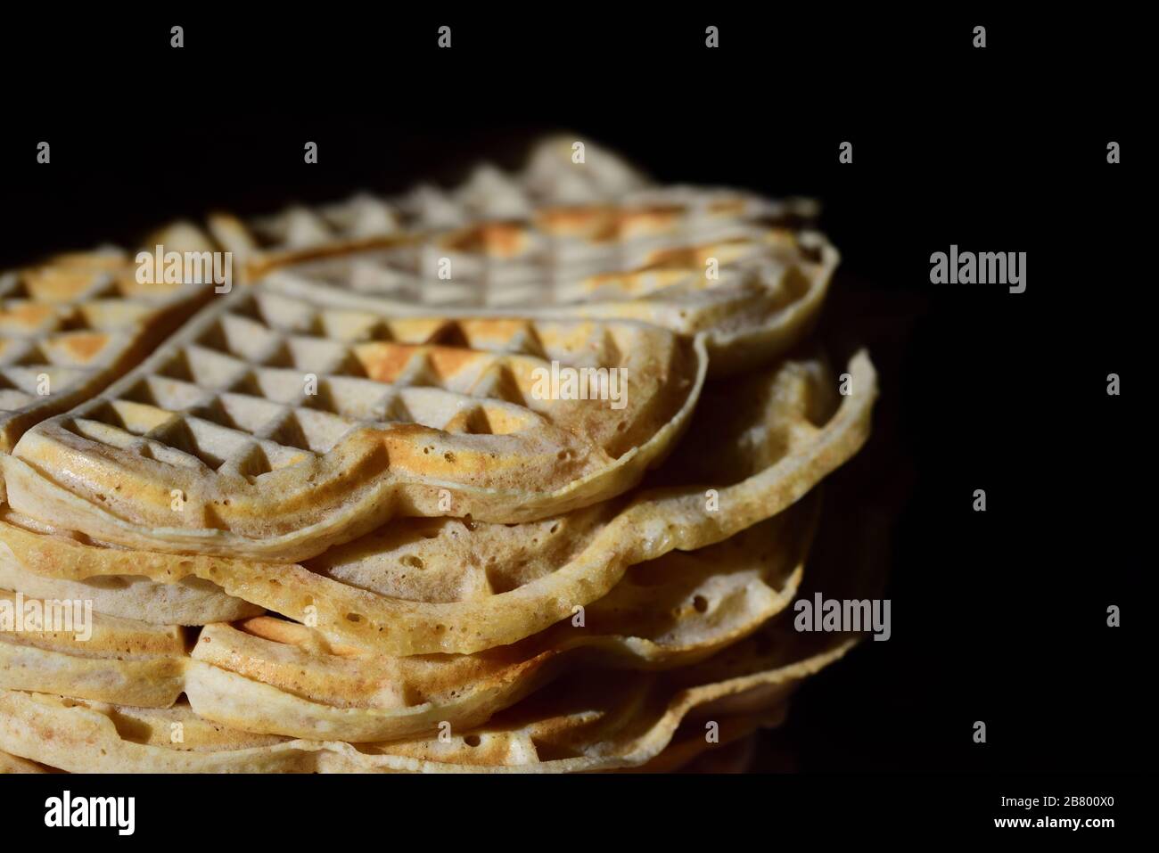 I waffle freschi fatti in casa sono accatastati su uno sfondo scuro con spazio per il testo Foto Stock