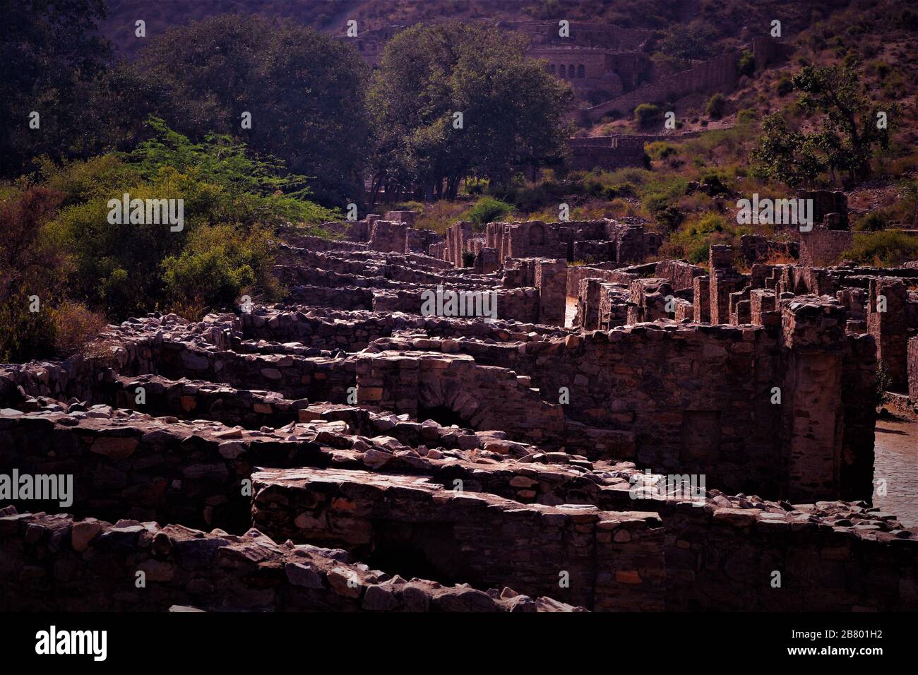 Resti architettonici di fortificazione di Bhangarh rovinata con le colline impressionanti nello sfondo, Alwar, Rajasthan, India Foto Stock