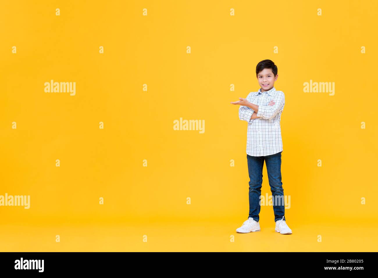 Ritratto a tutta lunghezza di sorridente giovane asiatico ragazzo facendo le braccia traversato gesto con palmo aperto in giallo isolato sfondo con spazio copia Foto Stock