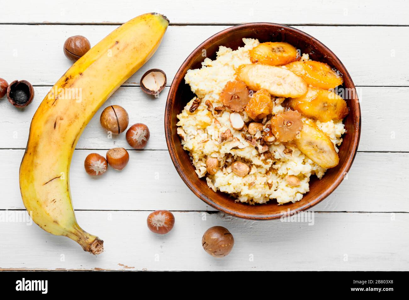 Porridge di miglio con banane caramellate e nuts.healthy colazione Foto Stock