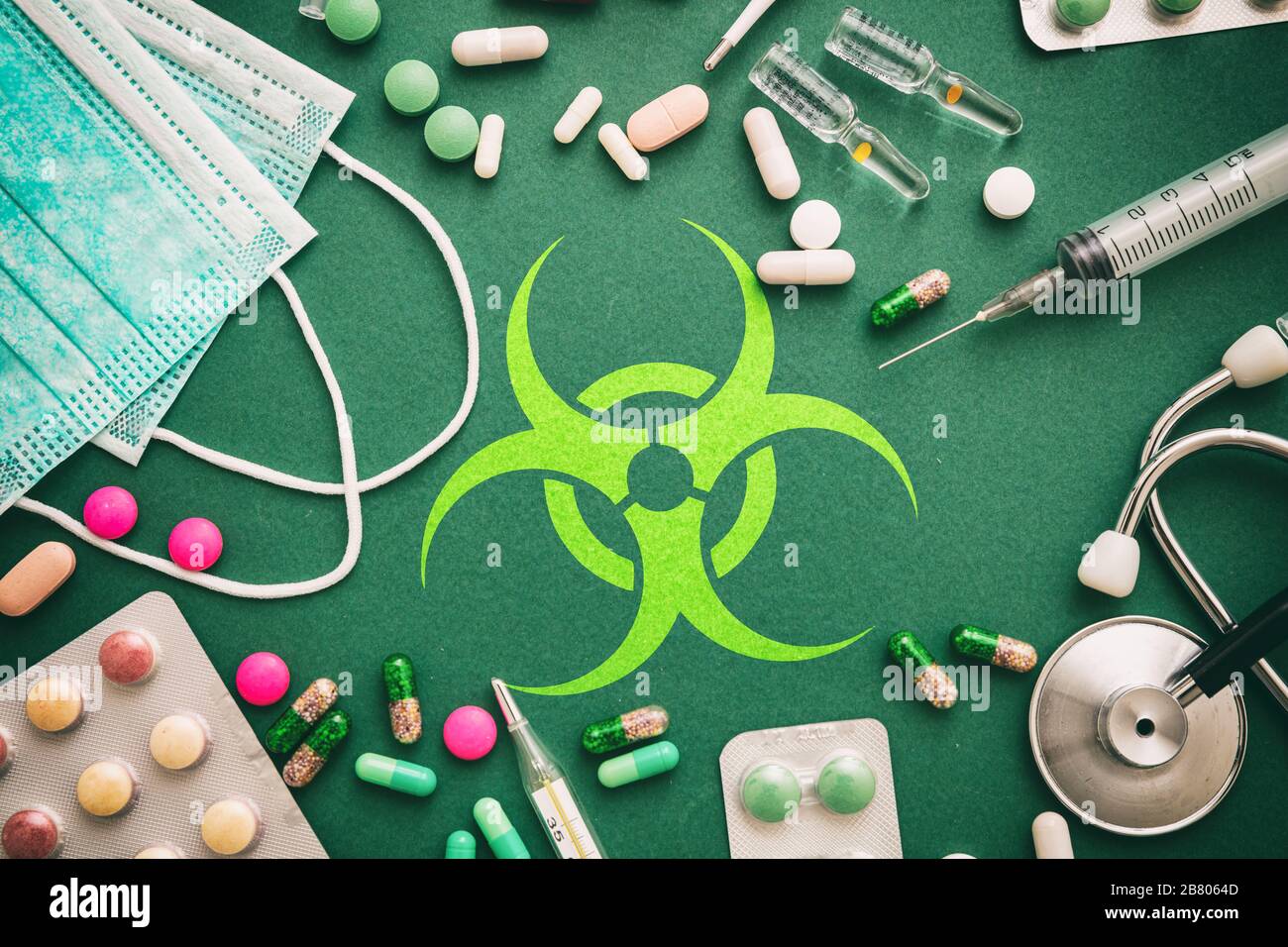 Virus flat Lay, concetto di terapia. Segno del virus su sfondo verde con strumenti medici e madicina, vista dall'alto Foto Stock