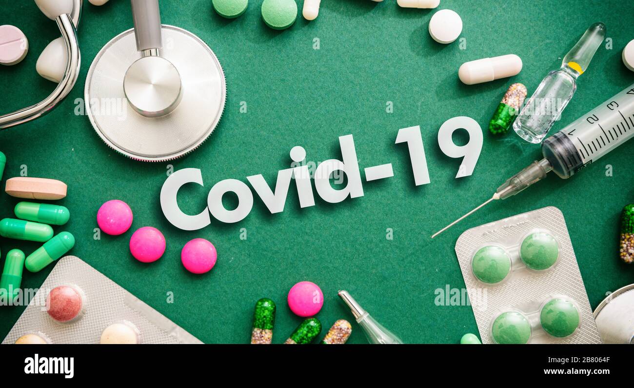 Coronavirus piatto laico, concetto di epidemia di virus. Testo Covid 19 su sfondo verde con strumenti medici e madicina, vista dall'alto Foto Stock