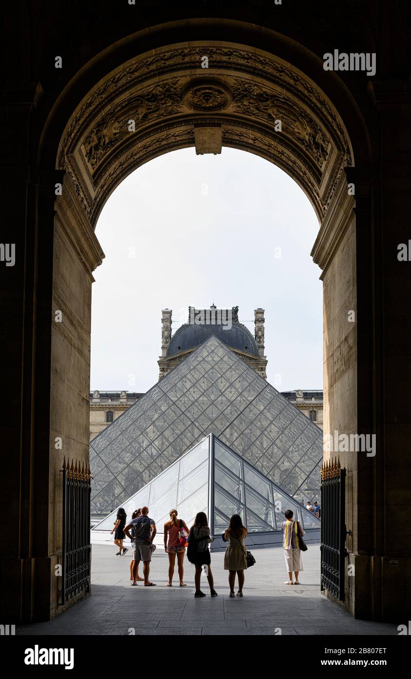 I visitatori ammirano il Museo del Louvre dal passaggio dell'Ala Richelieu Foto Stock