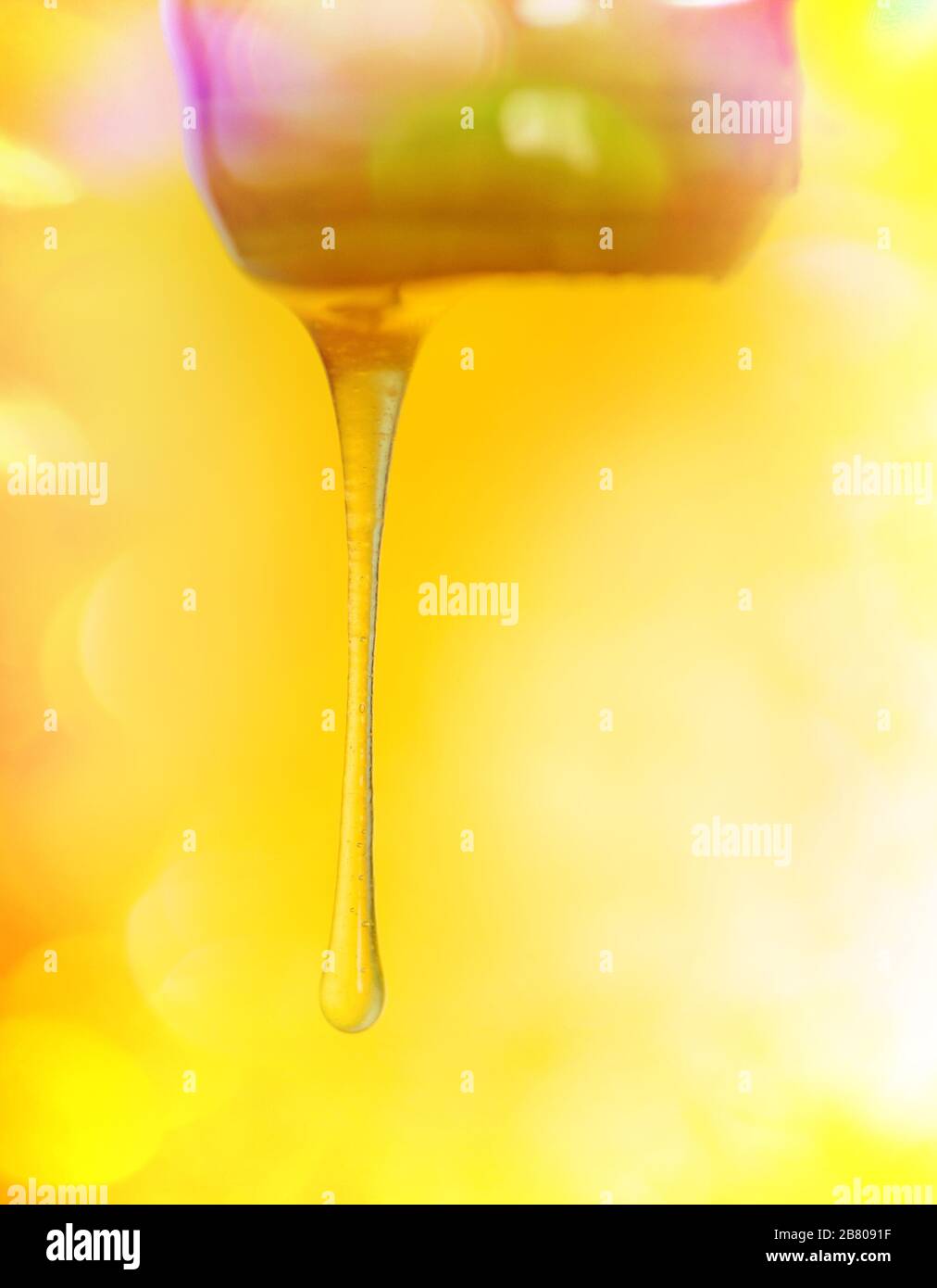 Miele bastone con miele versato. Flusso di miele dolce. Schizzi di miele dolce biologico. Miele che sgocciola con miele penetratore Foto Stock