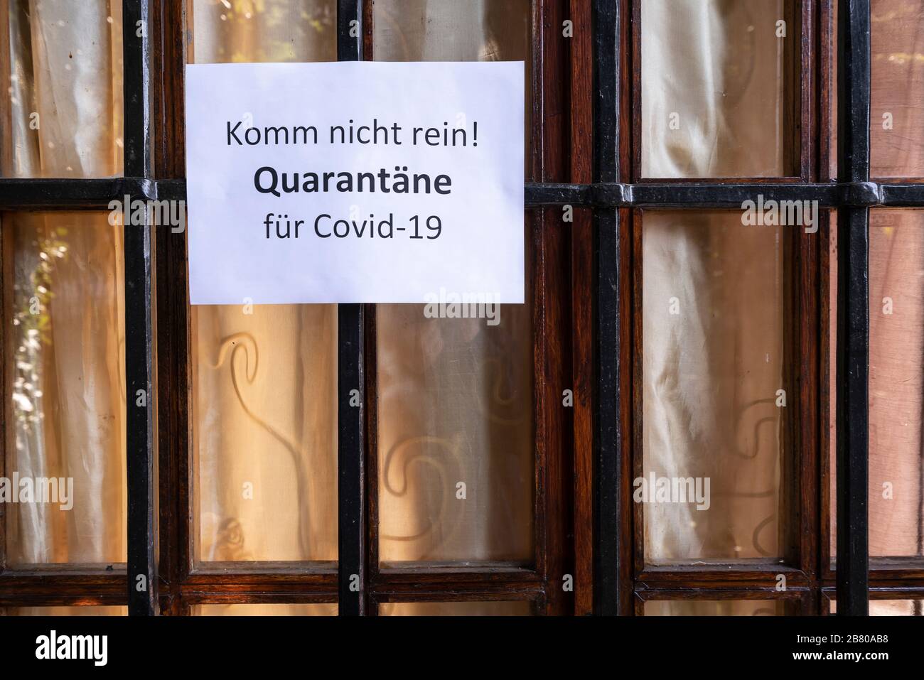 Il segno con il divieto di ingresso per la quarantena per il virus Covid-19 in lingua tedesca su una finestra principale Foto Stock