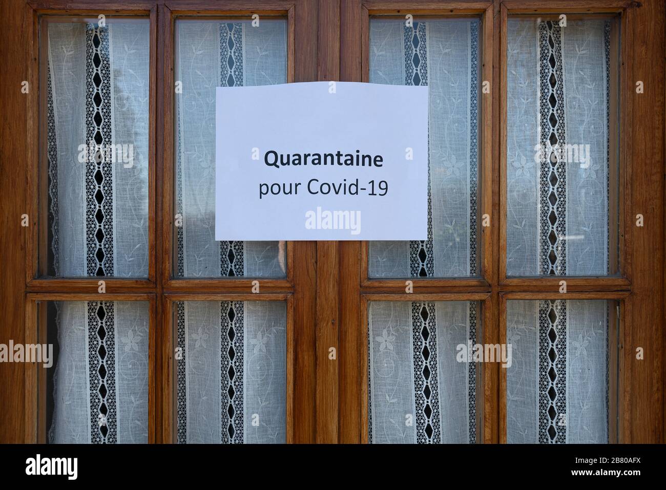 Il segno quarantena per il virus Covid-19 in lingua francese su una finestra di legno Foto Stock