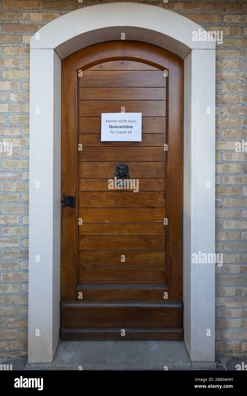 Il segno quarantena per il virus Covid-19 in lingua tedesca su una porta d'ingresso in legno Foto Stock