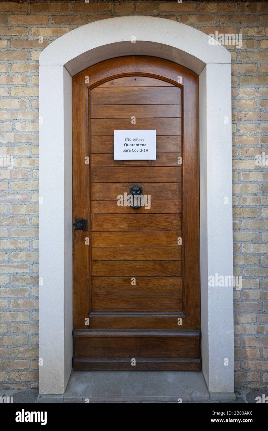 Il segno quarantena per il virus Covid-19 in lingua spagnola su una porta d'ingresso in legno Foto Stock