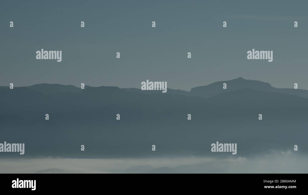 Silhouette di strati montuosi ricoperti di nebbia, la Mola, Catalogna Foto Stock