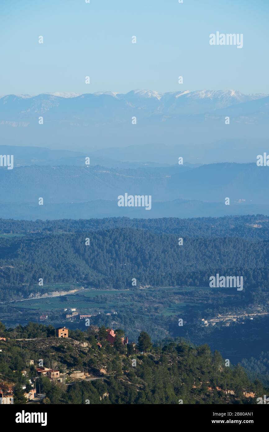 Lontane montagne innevate viste da un villaggio montano elevato, Montserrat, Catalogna Foto Stock