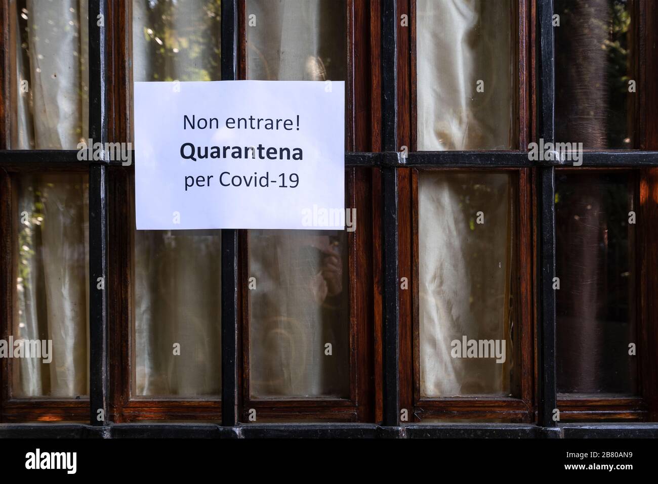 Il segno con il divieto di ingresso per la quarantena per il virus Covid-19 in italiano su una vetrina Foto Stock