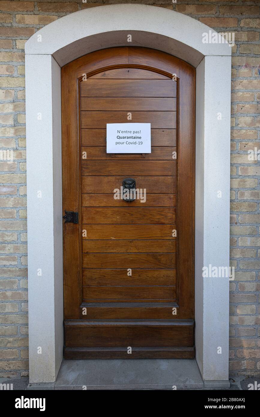 Il segno quarantena per il virus Covid-19 in lingua francese su una porta d'ingresso in legno Foto Stock
