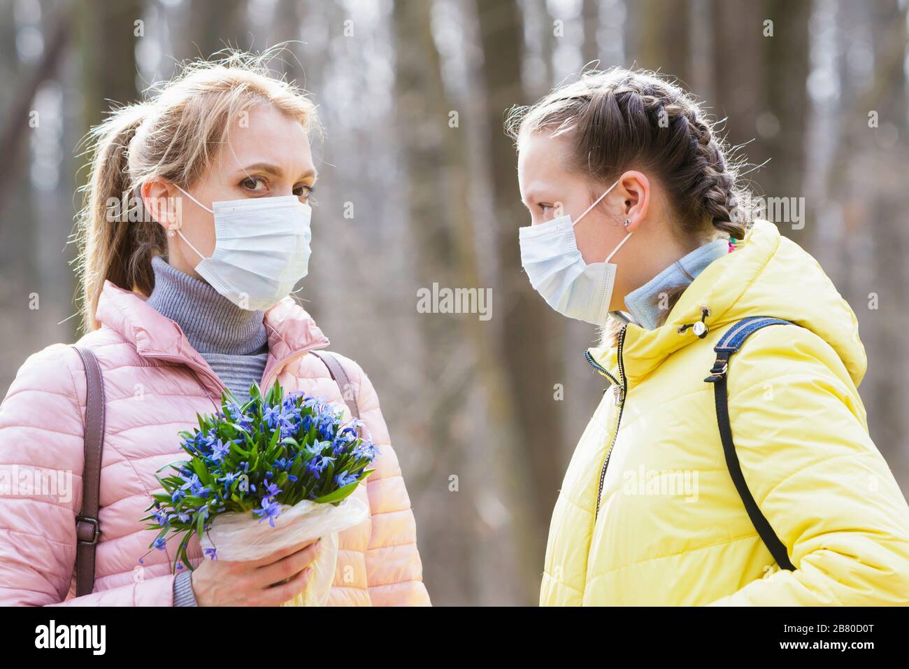 Ragazza e donna in maschere mediche in quarantena, strada Foto Stock