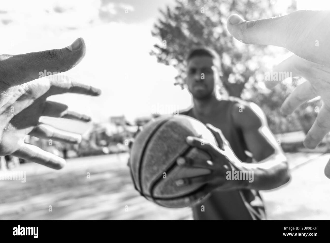 Giocatori di basket multirazziale sfidare in uno a uno gioco in campo urbano all'aperto con retroilluminazione - Atleta che si oppone al suo avversario africano - Focu Foto Stock
