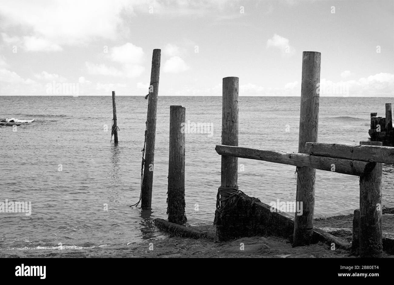 Castle Haven, Reeth Bay, Isola di Wight, Inghilterra, Regno Unito: Guardando fuori sul canale inglese in una giornata tranquilla, con una vecchia frangiflutti in primo piano. Fotografia a pellicola in bianco e nero Foto Stock