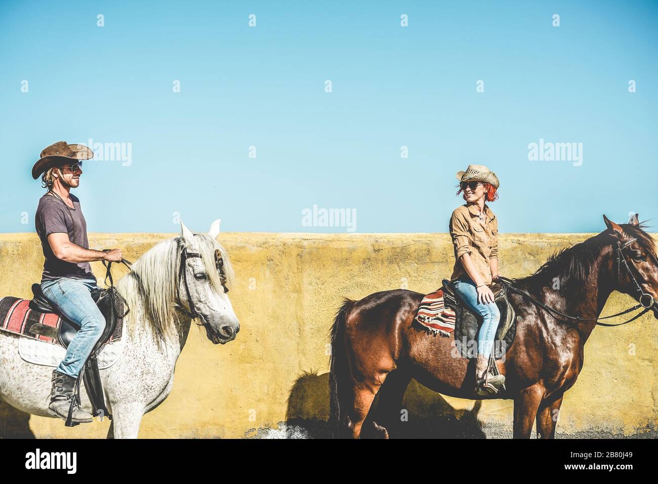 Coppia equitazione cavalli in campagna tour - Happy People divertirsi in estate giorno all'aperto - Vacanza, escursione, sano stile di vita, sport, amore betwee Foto Stock