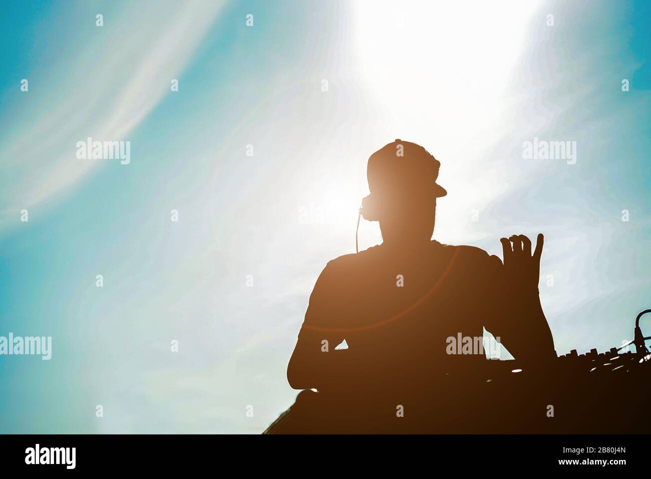 Silhouette of dj mixing outdoor with back Sun light - Ritratto di disco  jockey riproduzione di musica