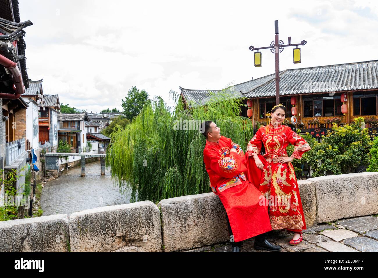 Una nuova coppia che indossa costumi tradizionali in posa per le foto di matrimonio nell'antica città di Shuhe vicino Lijiang, provincia di Yunnan, Cina. Foto Stock
