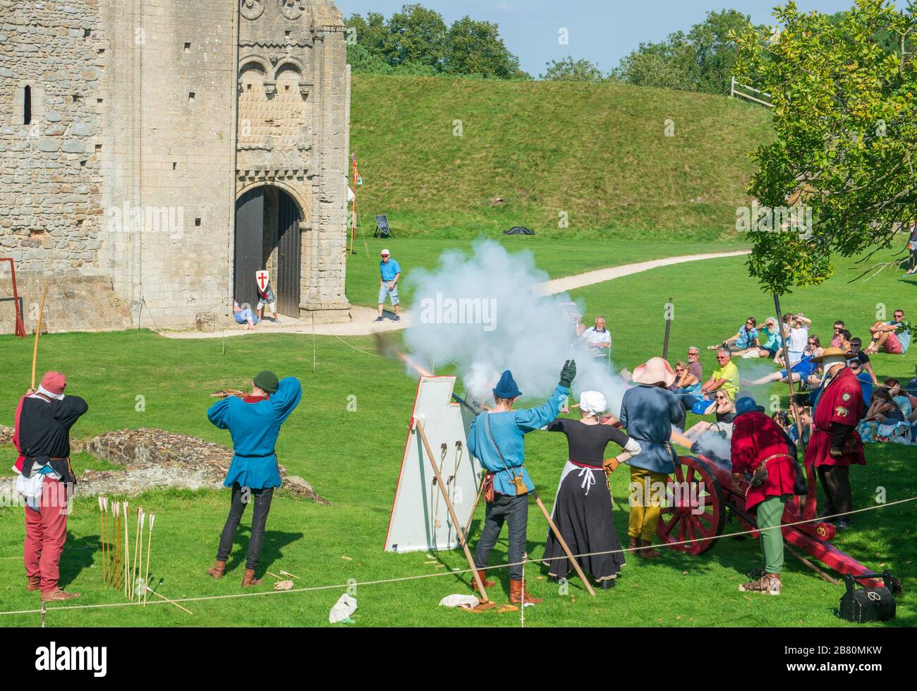 Re-enactor sparare una longbow, balestra, musket e cannone a Castle Rising a Norfolk Foto Stock