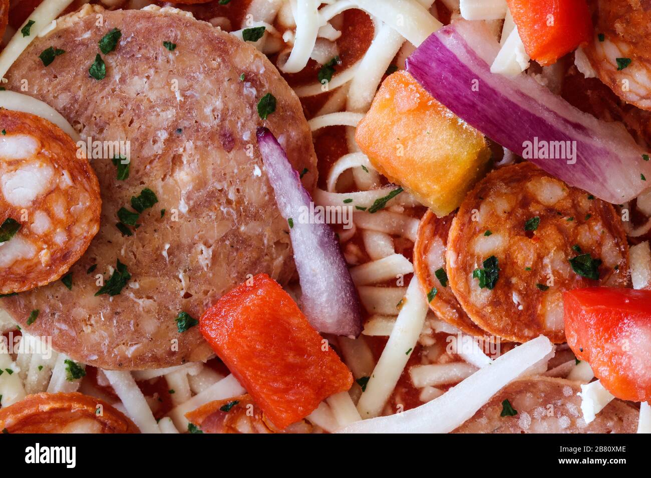 Ingredienti per pizza surgelati con salame, chorizo, cipolla rossa, pepe rosso e mozzarella grind Foto Stock