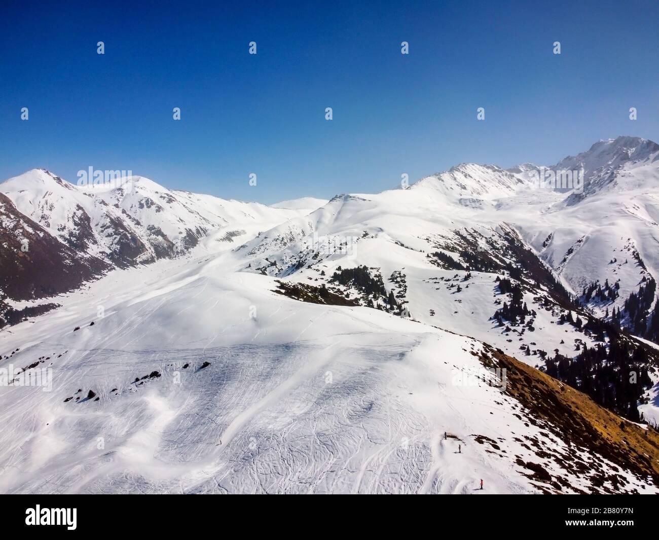 Vista aerea delle montagne invernali e del cielo blu. Orizzontale. Natura invernale. Volo sopra la base di sci. Montagne di Terskey Alatoo, Tian-Shan, Karakol, Kirghizistan. Foto Stock