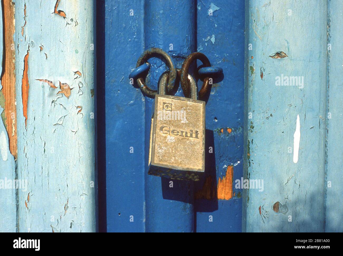 Particolare di una vecchia porta di legno chiusa, blu, su un edificio a Parga, Preveza, Epiro, Grecia. La vernice sulla porta è scricchiolante e incrinata. Foto Stock
