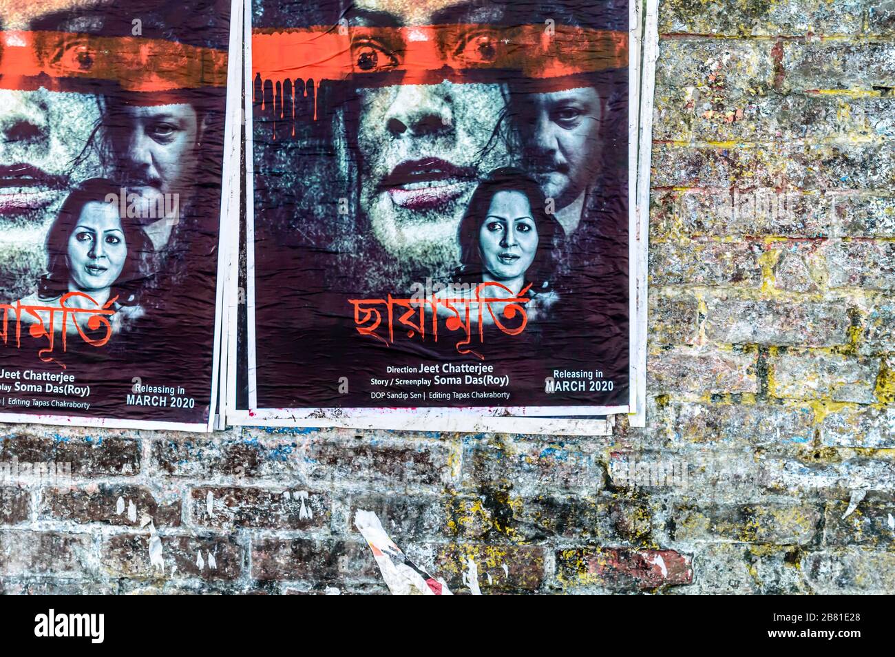 Bengali Tollywood film indiano poster su un vecchio muro di mattoni della strada della città. Tollygunge Kolkata West Bengala India Sud Asia Pacifico Marzo 2020 Foto Stock