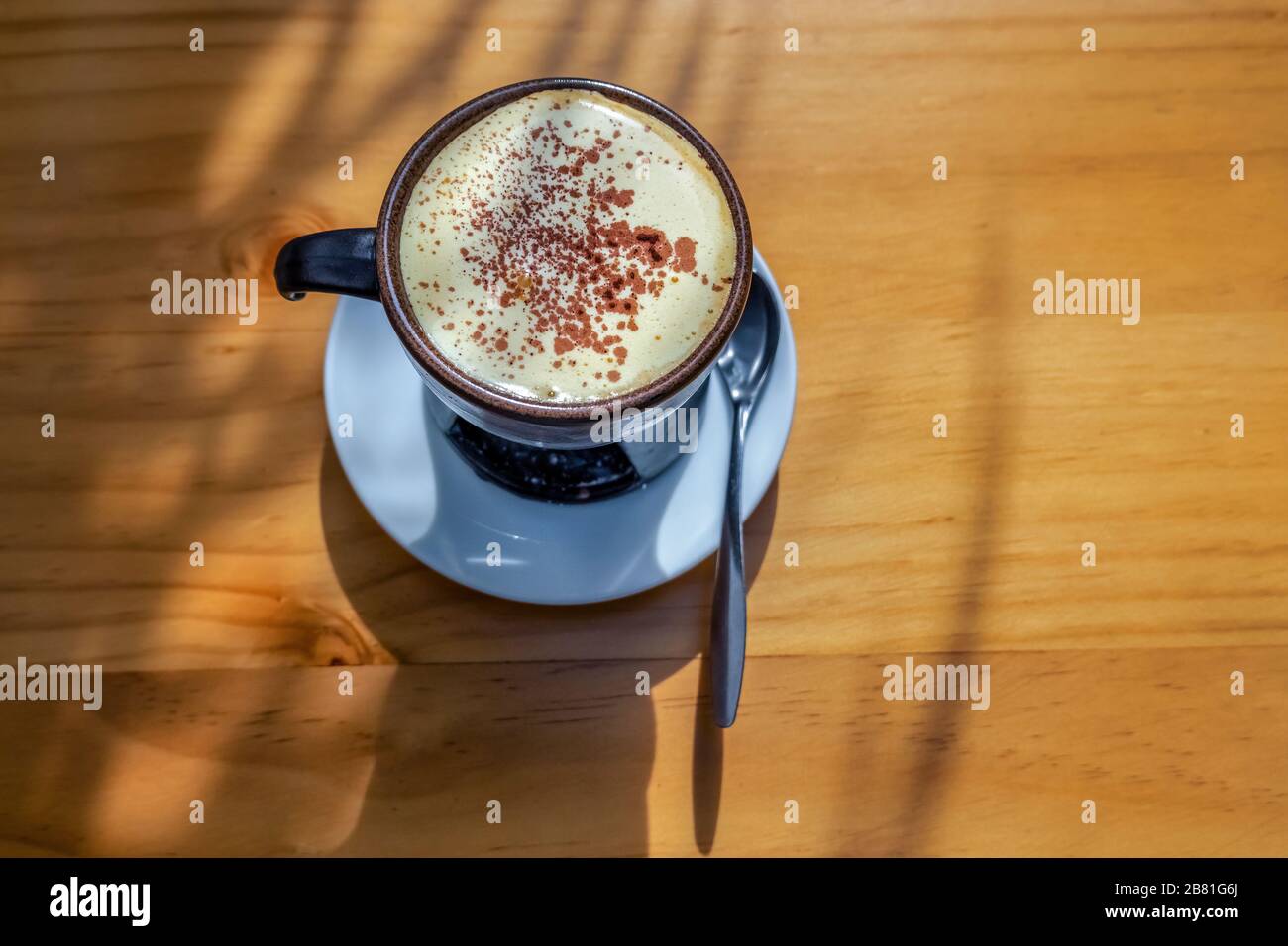 Vista dall'alto una tazza di caffè Egg su legno background.Famous caffè tradizionale vietnamita a ha noi, Vietnam. Le uova vengono sbattute con caffè, bevanda calda o wi-fi Foto Stock