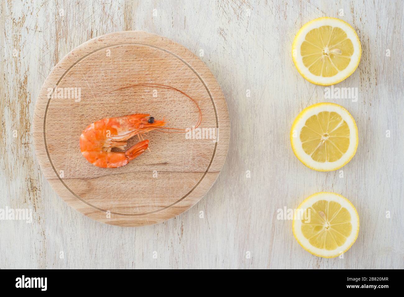 composizione con gamberi e limoni su un tavolo da cucina Foto Stock