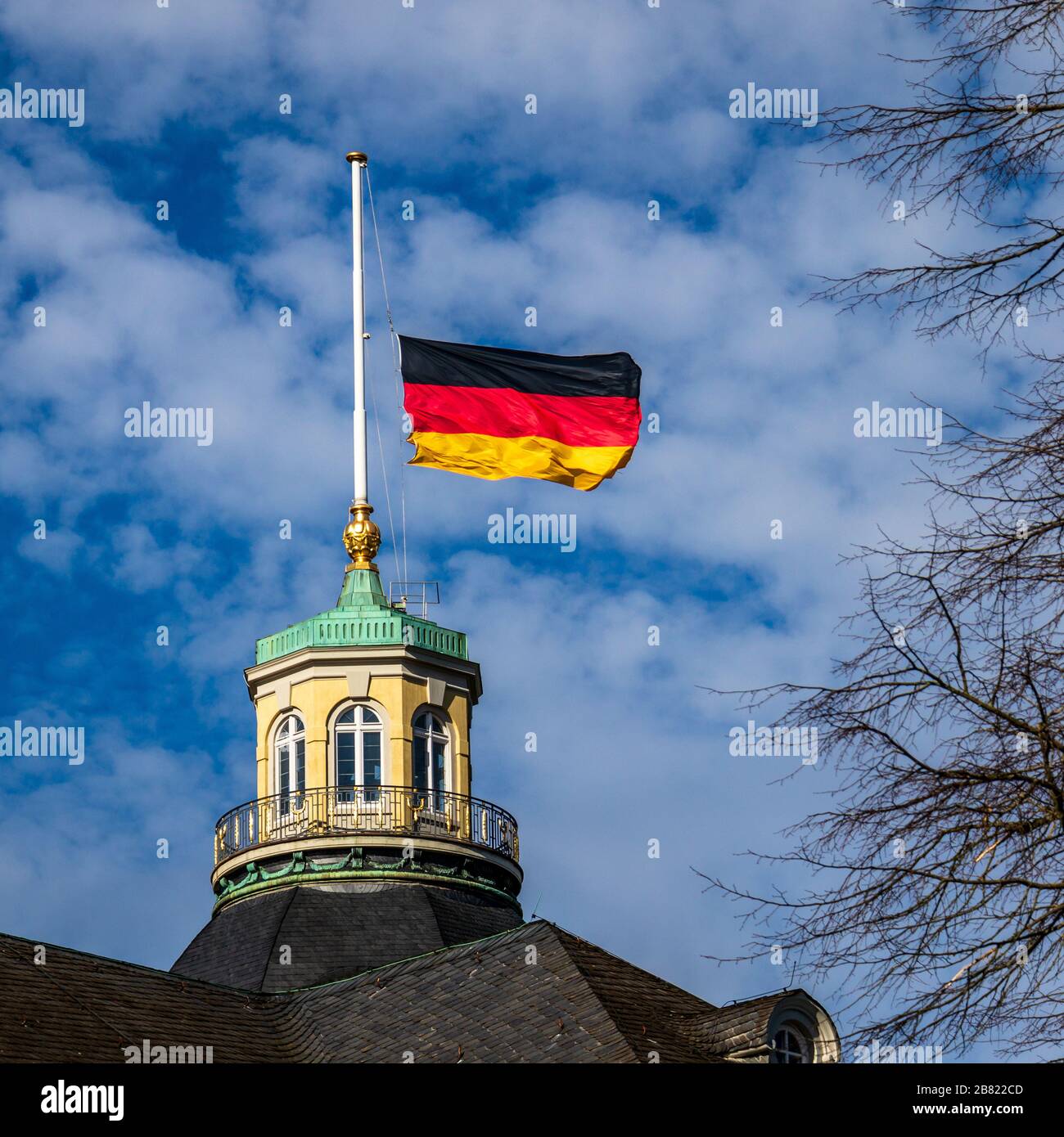 Vista ravvicinata sulla bandiera tedesca a Halfmast, auf Halbmast, sul tetto della torre del Castello di Karlsruhe, cielo blu dietro. Germania. Foto Stock