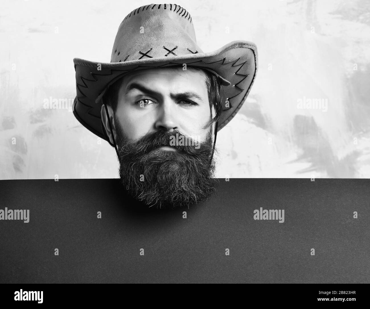 Uomo Barbuto, barba lunga. Brutali gravi caucasico barba lunga hipster in  vintage cappello da cowboy di carta blu con foglio in studio su sfondo  colorato Foto stock - Alamy