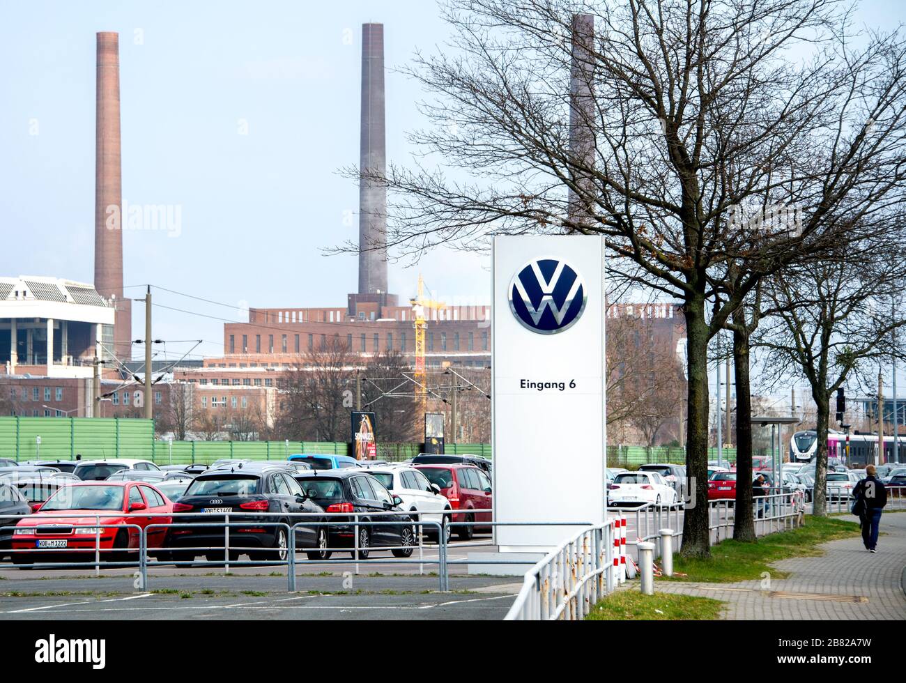 19 marzo 2020, bassa Sassonia, Wolfsburg: Il logo Volkswagen AG si trova all'ingresso di un parcheggio per dipendenti di fronte allo stabilimento. Il crescente rischio di infezione e le drastiche conseguenze economiche della crisi corona costringeranno Volkswagen a chiudere i suoi impianti in Germania da giovedì sera (19 marzo 2020). Foto: Hauke-Christian Dittrich/dpa Foto Stock
