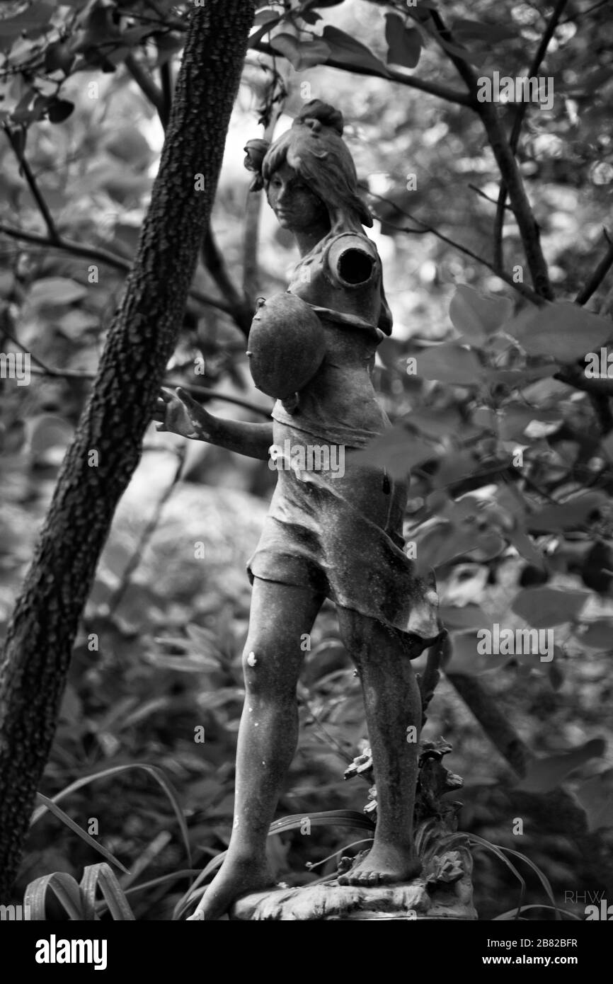 Foto in bianco e nero della statua di una donna in un giardino Foto Stock