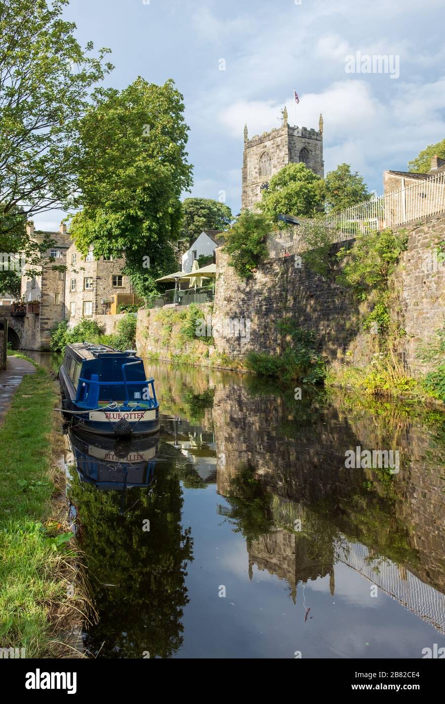 Narrowboats sul canale Thanet a Skipton. Chiesa della Santissima Trinità sullo sfondo Foto Stock