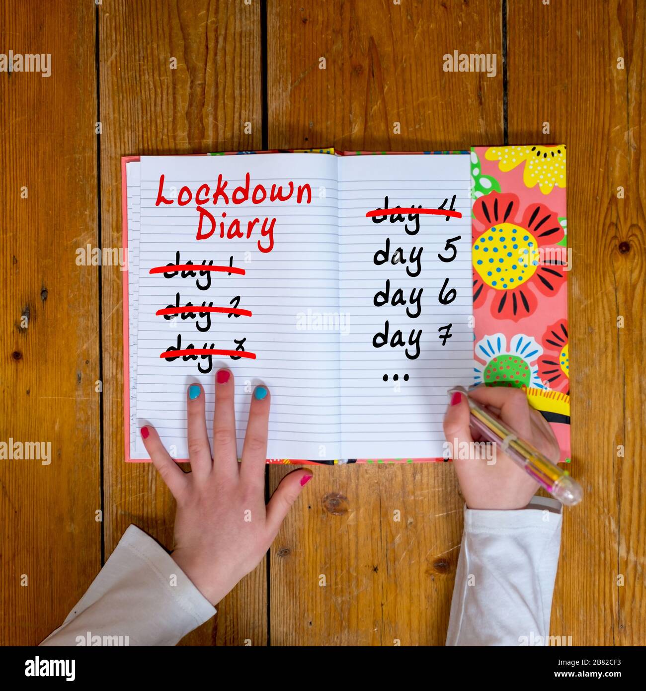 Ragazza che conta giù i giorni di blocco in un diario Foto Stock
